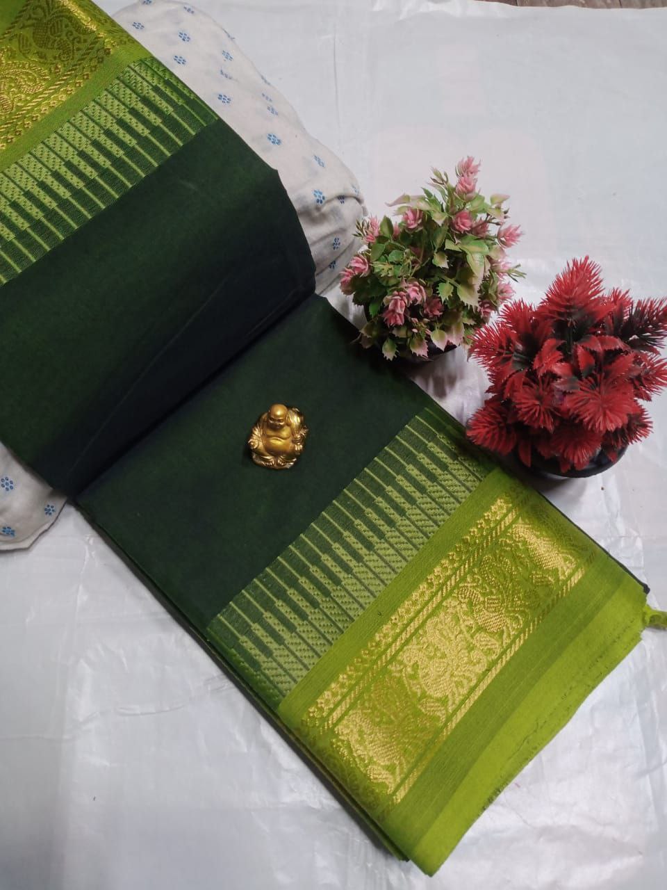 Dark green saree with a light green zari border.